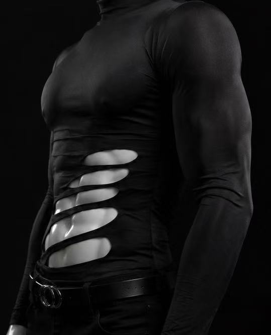 Side view of black cutout long sleeve top highlighting asymmetric side openings and unique garment construction